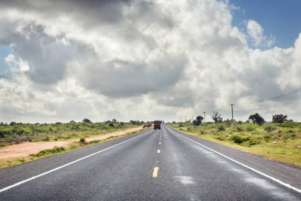 African highway from Mombasa to Nairobi in Kenya, straight asphalt road and surrounding plains